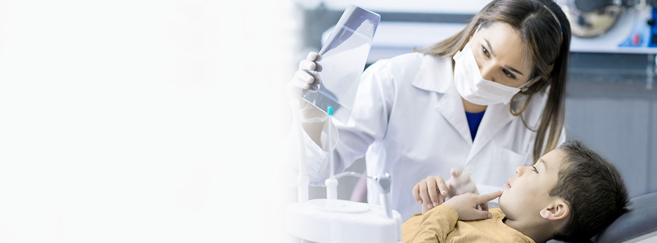 Fogászati ​​szakember, aki biztonsági személyi védőfelszerelést és fehér laboratóriumi kabátot visel együttérzően